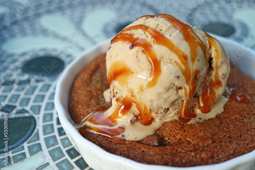 Closeup Mouthwatering Texture of Warm Cookie Topped with Ice Cream and Salted Caramel Sauce photo