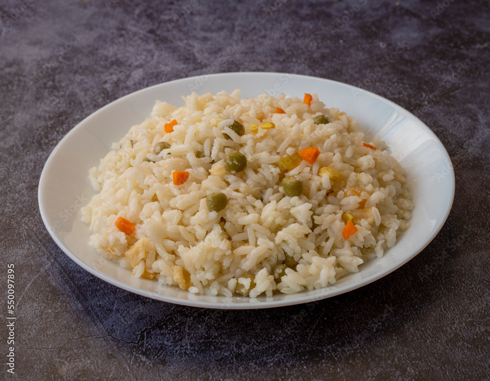Vegan rice with vegetables, shot from above on a black background Vegan rice with vegetables, shot from above on a black background