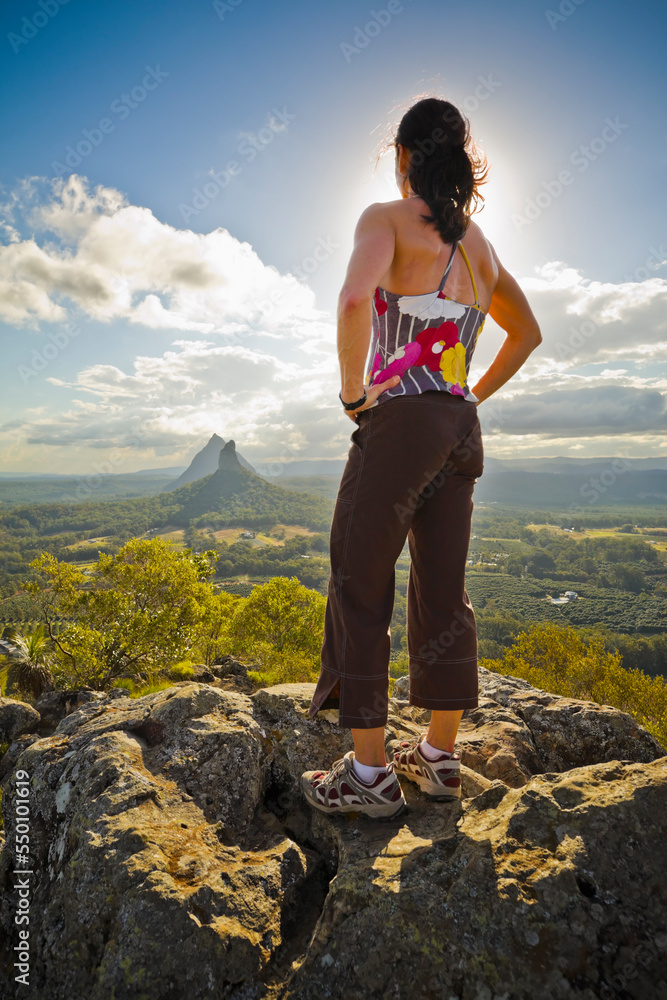 A woman stands on the summit of Mount Ngun Ngun in the Glasshouse mountains, Queensland, Australia A woman stands on the summit of Mount Ngun Ngun in the Glasshouse mountains, Queensland, Australia