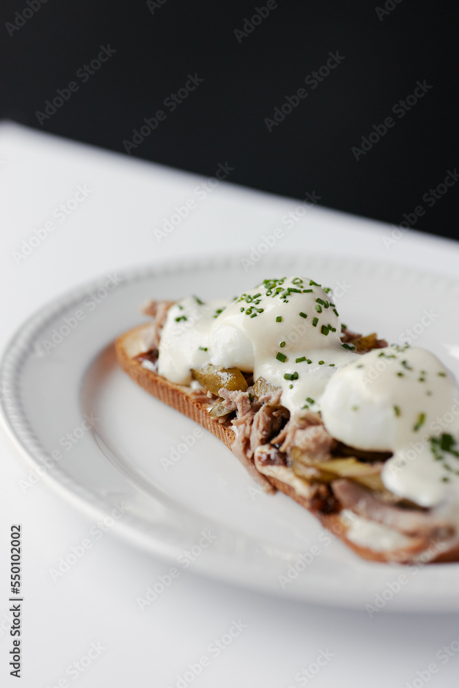 sandwich with poached egg and stew, drizzled with cheese and herbs sandwich with poached egg and stew, drizzled with cheese and herbs
