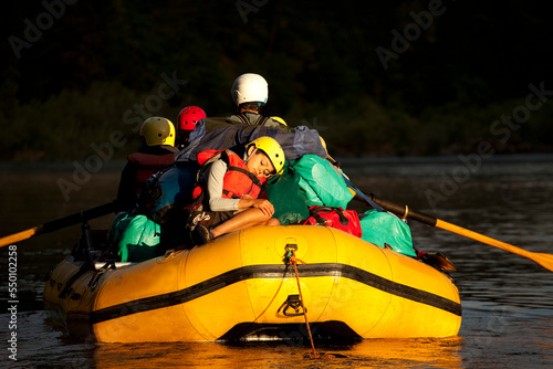 One boy sleeping on the back of a raft in golden light. photo