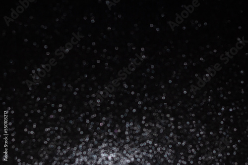 Fundo preto natalino cheio de brilhos de gliter. Fundo preto com brilhos desfocados. photo