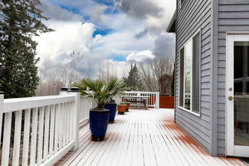 Early winter or late autumn snow fall blanketing home outdoor patio
