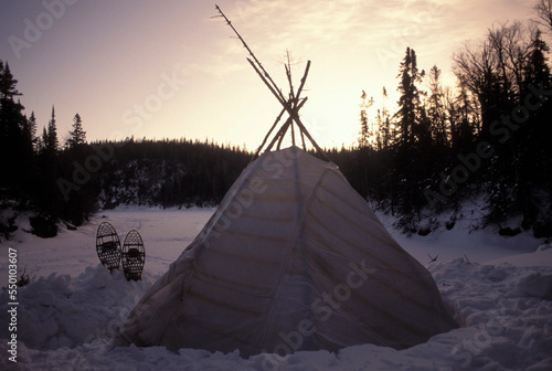 Winter sunset over a teepee in snow. photo