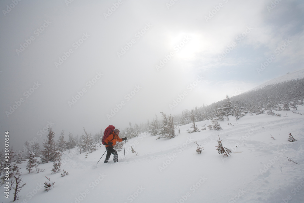 A man hiking through the snow on Mt. Washington. A man hiking through the snow on Mt. Washington.