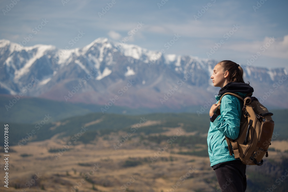 Lonely backpacker girl is trekking in the mountains