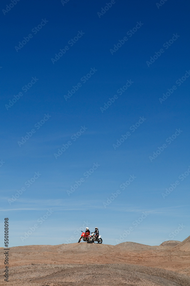 Young men take a break from riding dirt bikes during a motocross trip to the surreal dunes of the Painted Desert near Cameron, AZ. Young men take a break from riding dirt bikes during a motocross trip to the surreal dunes of the Painted Desert near Cameron, AZ.
