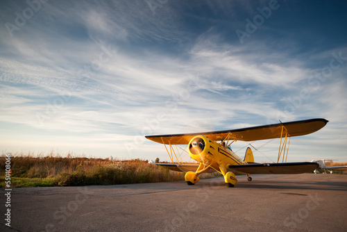 Old yellow bi-plane on the runway photo