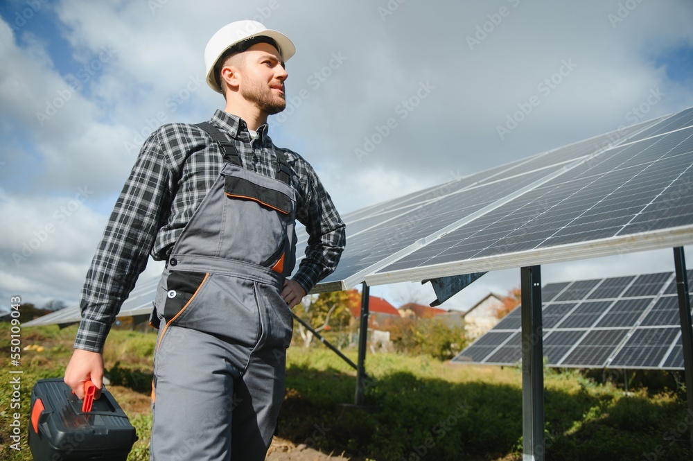 Solar power plant worker checks the condition of the panels Solar power plant worker checks the condition of the panels