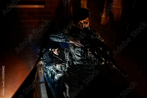 An Air Force Security Forces squad clear the stairwell of a training building during a simulated hostage situation.