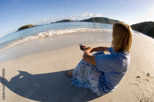 A woman listening to her ipod on Cinnamon Bay Beach on St. John, Virgin Islands. photo
