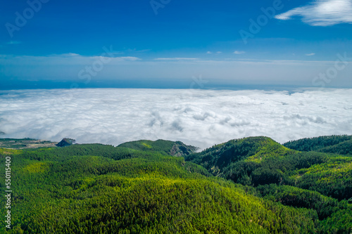 Wide mountain panorama with blue sunny sky and white puffy sea of clouds below in Tenerife island  Spain