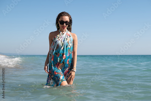 beautiful and happy girl on the sea of the sea in bright stylish summer clothes