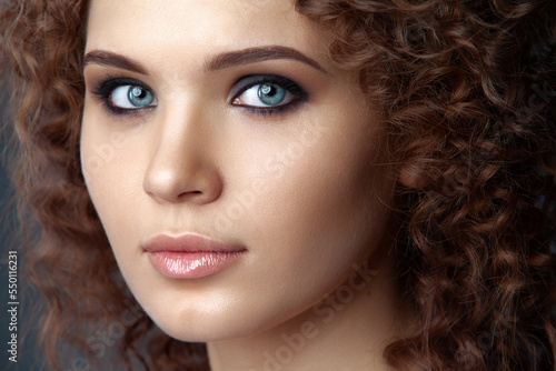 Portrait of a young attractive brunette woman with curly hair