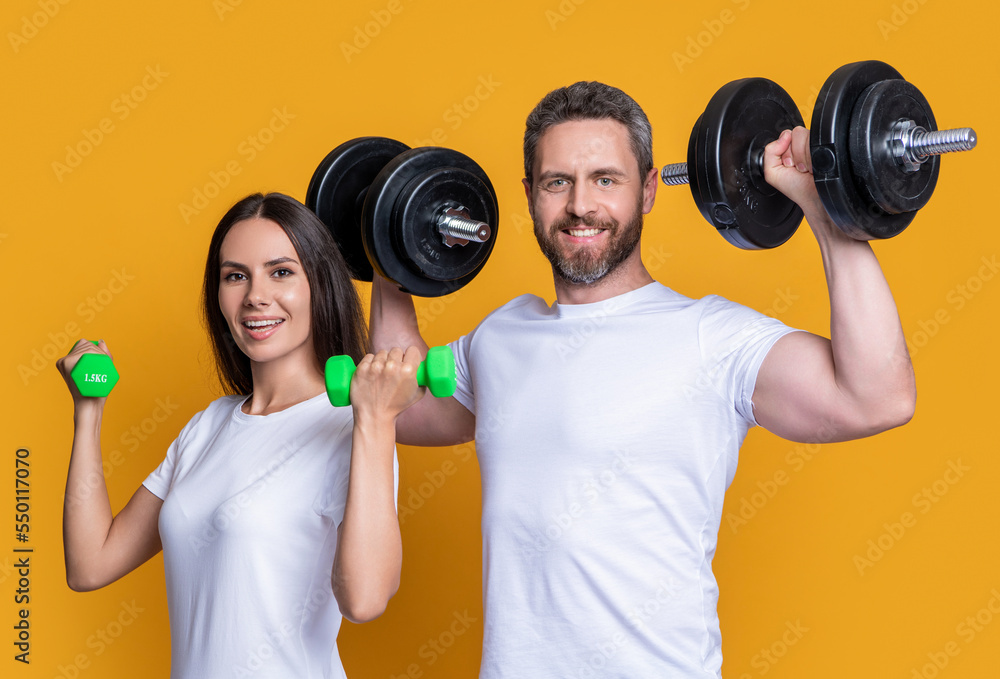 strong sport couple with dumbbell in gym. photo of sport couple with dumbbell. sport couple strong sport couple with dumbbell in gym. photo of sport couple with dumbbell. sport couple