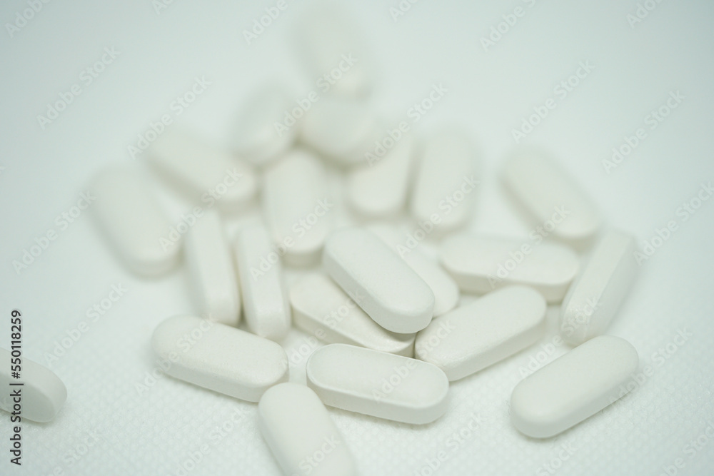  Heap of medical white pills on a white background            