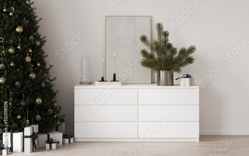 Christmas decor on a white cabinet, Christmas tree branches in a vase. Christmas tree on the floor with toys and gifts, decorated with garlands