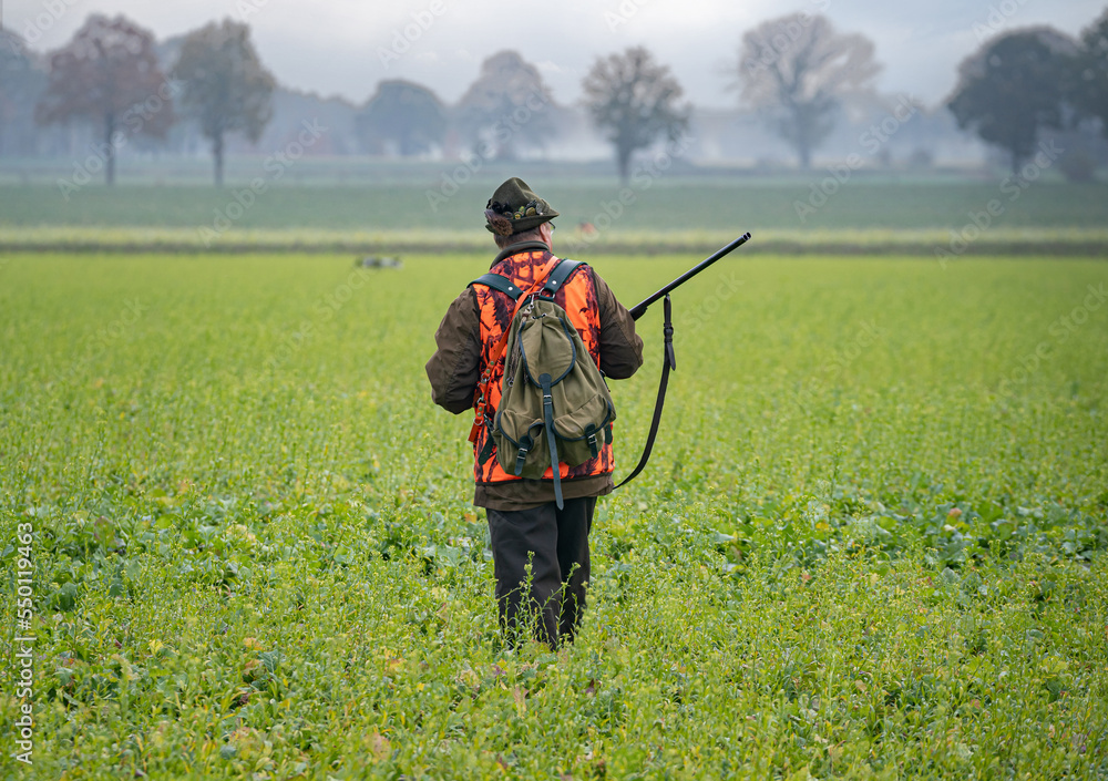 Ausrüstung bei einer Jagd: Schrotflinte, Signalkleidung, Rucksack. Ausrüstung bei einer Jagd: Schrotflinte, Signalkleidung, Rucksack.