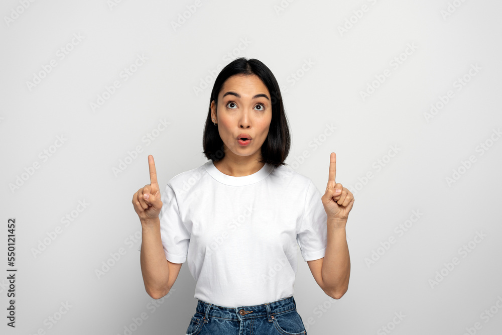 Surprised girl pointing up and looking with shocked face Surprised girl pointing up and looking with shocked face