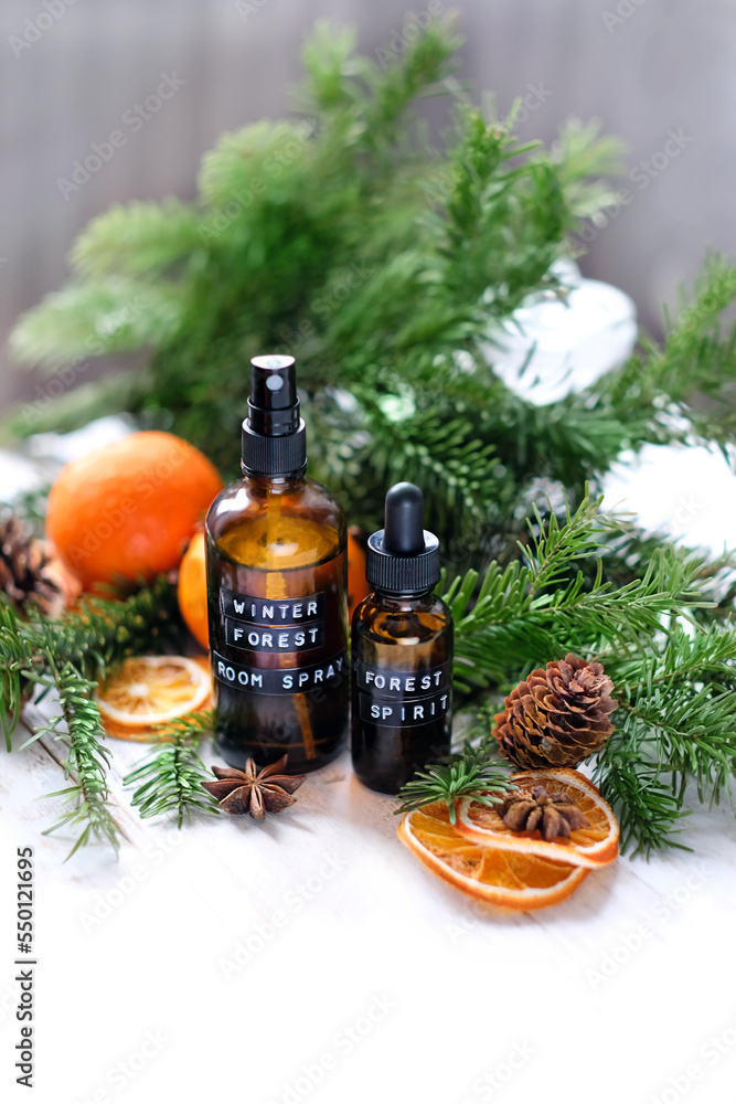 dark glass spray bottles, citrus fruits, cinnamon sticks, fir branches on table, abstract background. Sustainable lifestyle, ecological product. Homemade natural aroma spray, zero waste concept dark glass spray bottles, citrus fruits, cinnamon sticks, fir branches on table, abstract background. Sustainable lifestyle, ecological product. Homemade natural aroma spray, zero waste concept