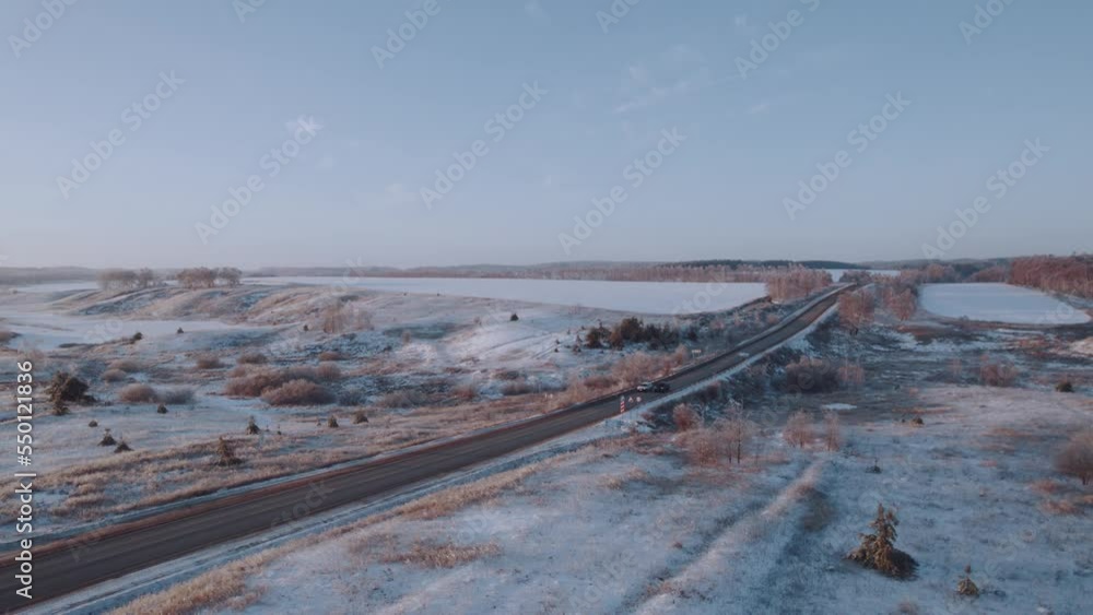 Aerial photography of the highway in winter along the forest at sunset, car traffic in winter. Aerial photography of the highway in winter along the forest at sunset, car traffic in winter.