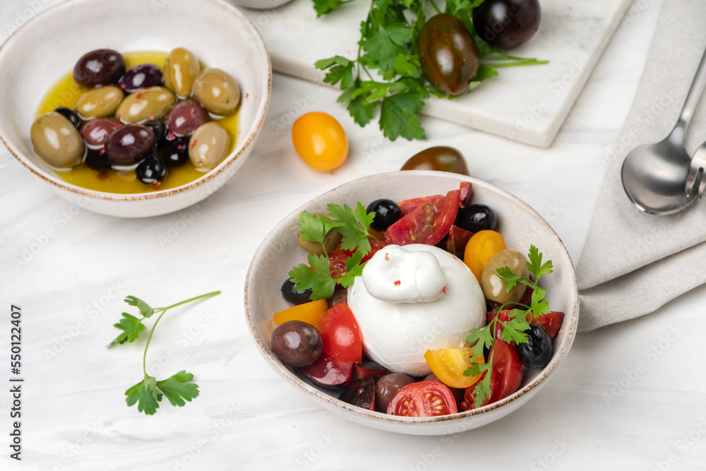 burrata cheese salad with tomatoes, olives and olive oi