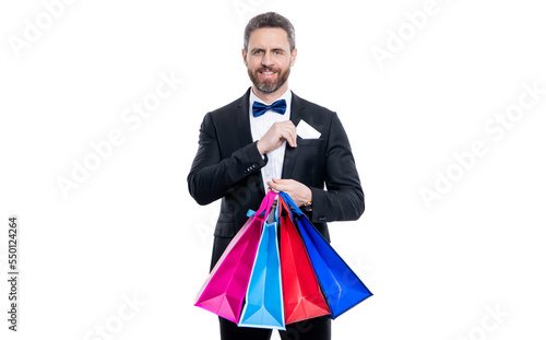 studio shot tuxedo man hold shopping bag and card in pocket. purchase of tuxedo man go shopping