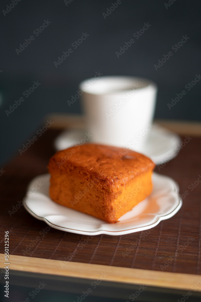 coffee and orange cake on a black background and porcelain tableware on a brown tapere coffee and orange cake on a black background and porcelain tableware on a brown tapere