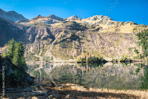 Tranquil image of Lake Cavloc in Maloja region in the Swiss Alps on a sunny autumn day photo