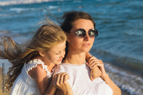 Portrait of mother and daughter on the seashore on a warm sunny evening © Sergey Chayko