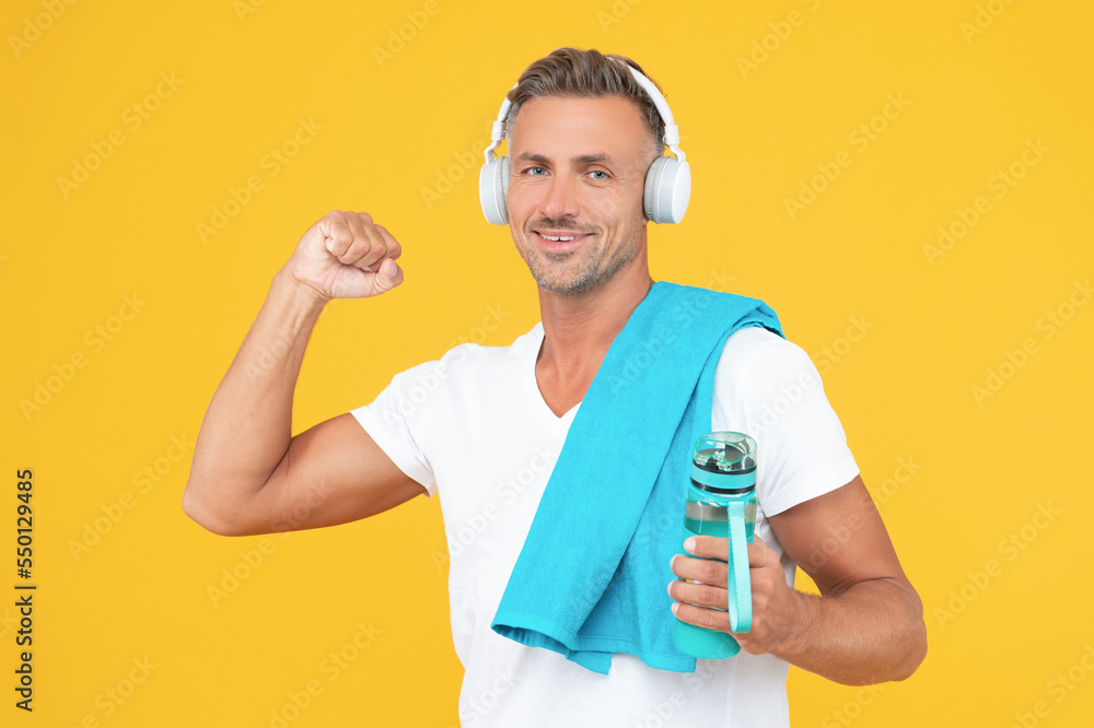 successful fitness man holding sport bottle in studio. fitness man with towel and bottle successful fitness man holding sport bottle in studio. fitness man with towel and bottle