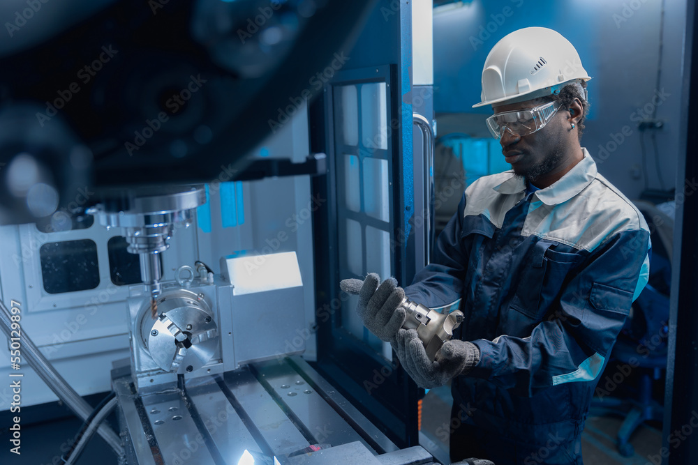 Professional african american engineer man working on CNC machinery, blue toning. Concept industry factory people Professional african american engineer man working on CNC machinery, blue toning. Concept industry factory people