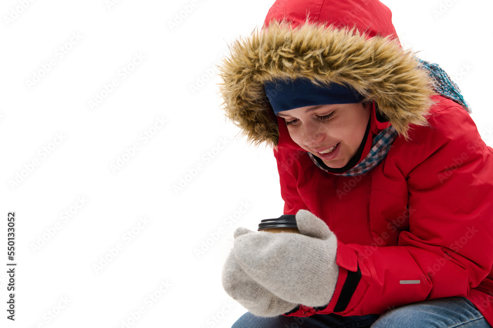 Preteen child boy, cute traveler adventurer in warm clothes, warming up, holding a disposable paper cup of hot drink, isolated over white background with free advertising space. Winter travel concept Preteen child boy, cute traveler adventurer in warm clothes, warming up, holding a disposable paper cup of hot drink, isolated over white background with free advertising space. Winter travel concept