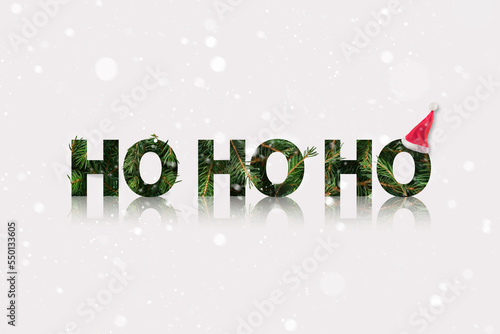 Santa ho ho ho sound made of a fir branch with Santas hat in the end. Winter Christmas theme with snow.