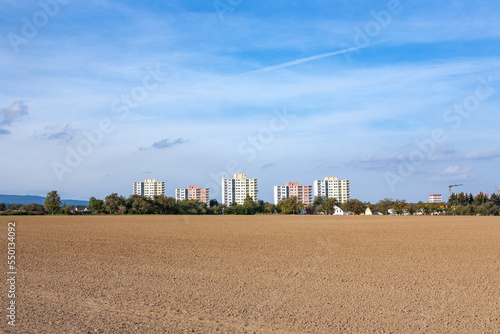view to social housing projects with plowed field in foreground in Steinbach near Frankfurt,