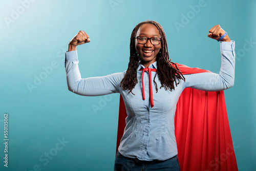 Fotografiet Happy positive justice defender flexing arms as a sign of strength while standing on blue background