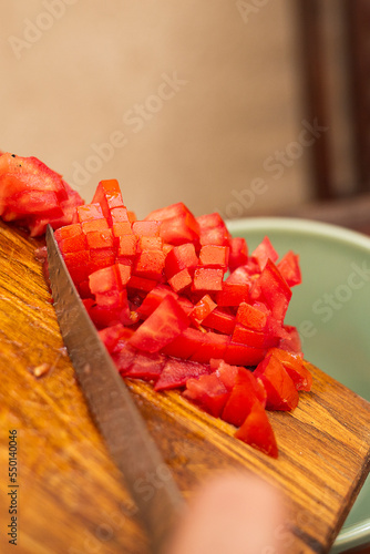 person placing diced tomatoes for cooking