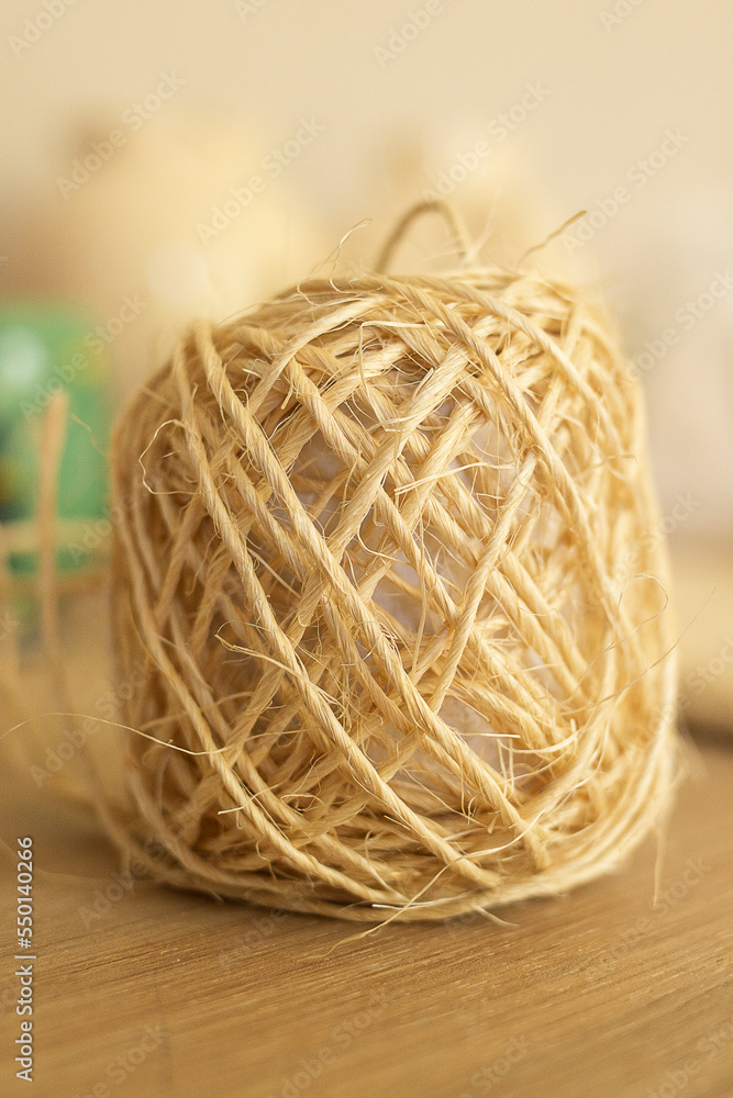 roll of natural thread on a wooden table roll of natural thread on a wooden table