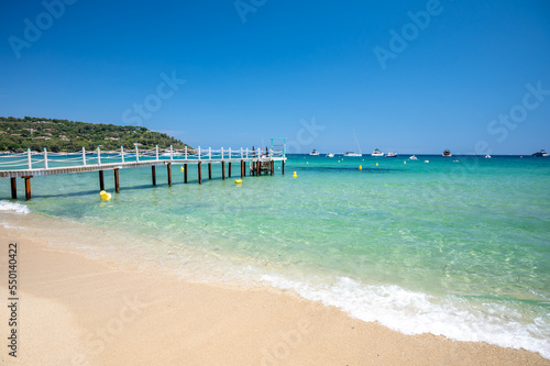 Wooden pier for guests of yachts on legendary Pampelonne beach near Saint-Tropez, summer vacation on white sandy beaches of French Riviera, France