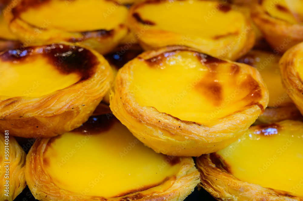 Portugal's traditional sweet dessert Pastel de nata egg custard tart pastry served with view on display in bakery, Lisbon area, Portugal Portugal's traditional sweet dessert Pastel de nata egg custard tart pastry served with view on display in bakery, Lisbon area, Portugal