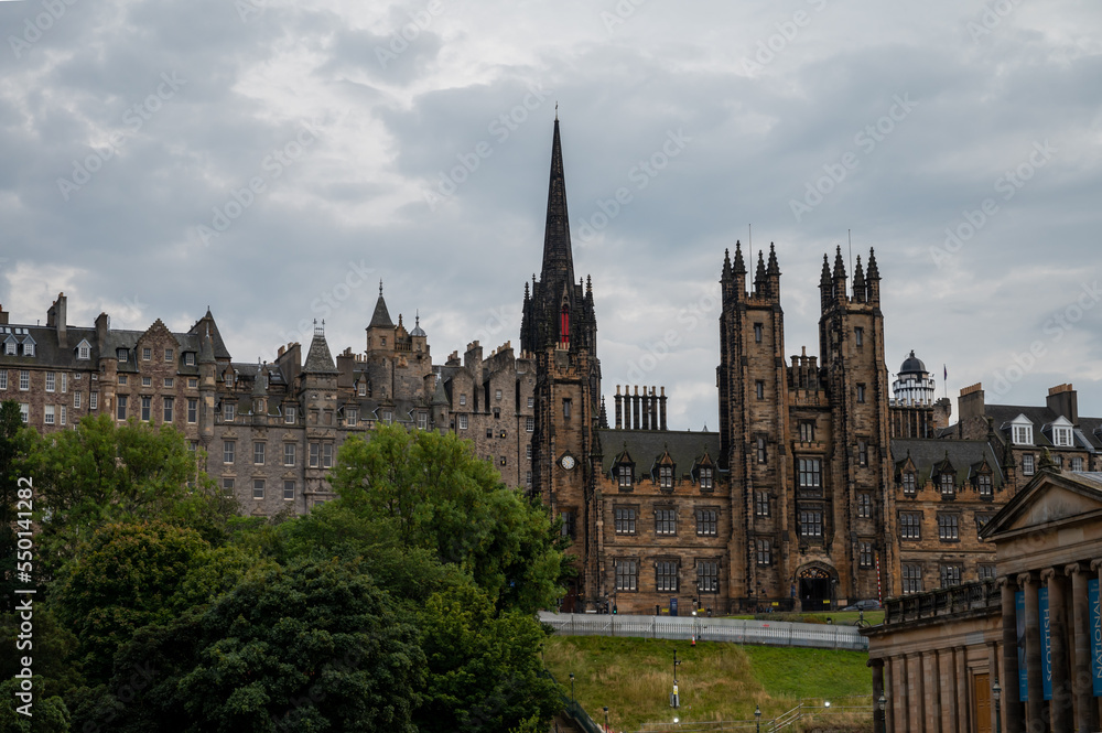 View from Princes street to old town and castle in Edinburgh city, view on houses, hills and trees in old part of the city, Scotland, UK