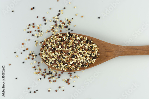 quinoa seed mix in a wooden spoon on white background isolated top view
