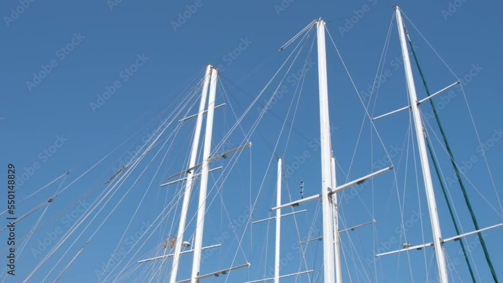 Yacht masts without sails. A nice luxury marine yachts without sails stay by the sunny beach. A concept of luxury resort during summer vacation. Yacht masts without sails. A nice luxury marine yachts without sails stay by the sunny beach. A concept of luxury resort during summer vacation.