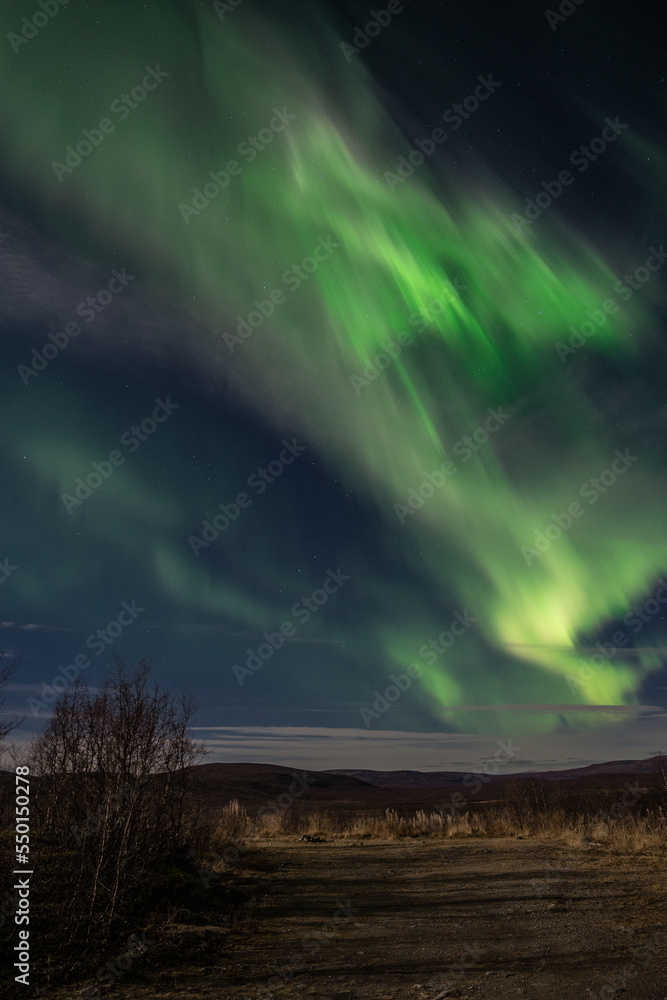 Aurora borealis over the hilly landscape in Northern Finland.