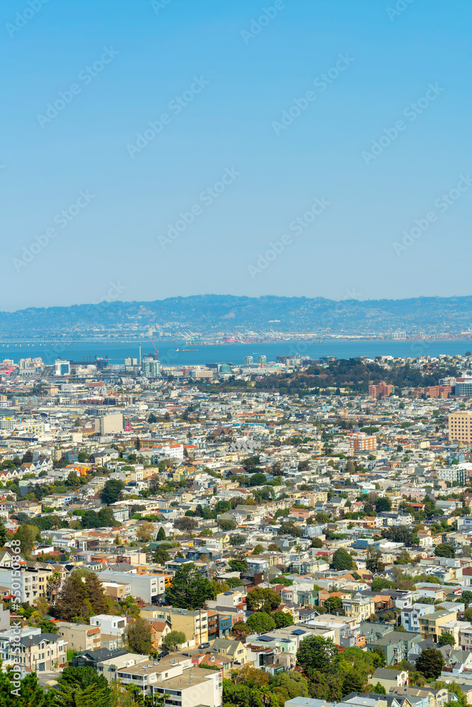 Beautiful downtown San Francisco city landscape with sprawling neighborhoods and ocean and moutain background late afternoon in sun