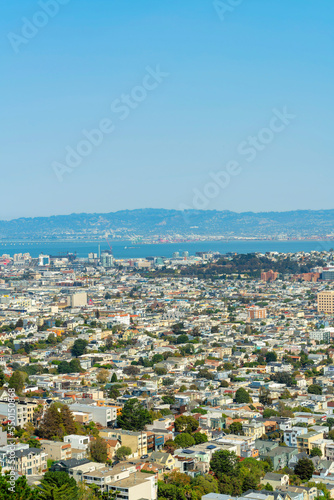 Fototapeta Naklejka Na Ścianę i Meble -  Beautiful downtown San Francisco city landscape with sprawling neighborhoods and ocean and moutain background late afternoon in sun