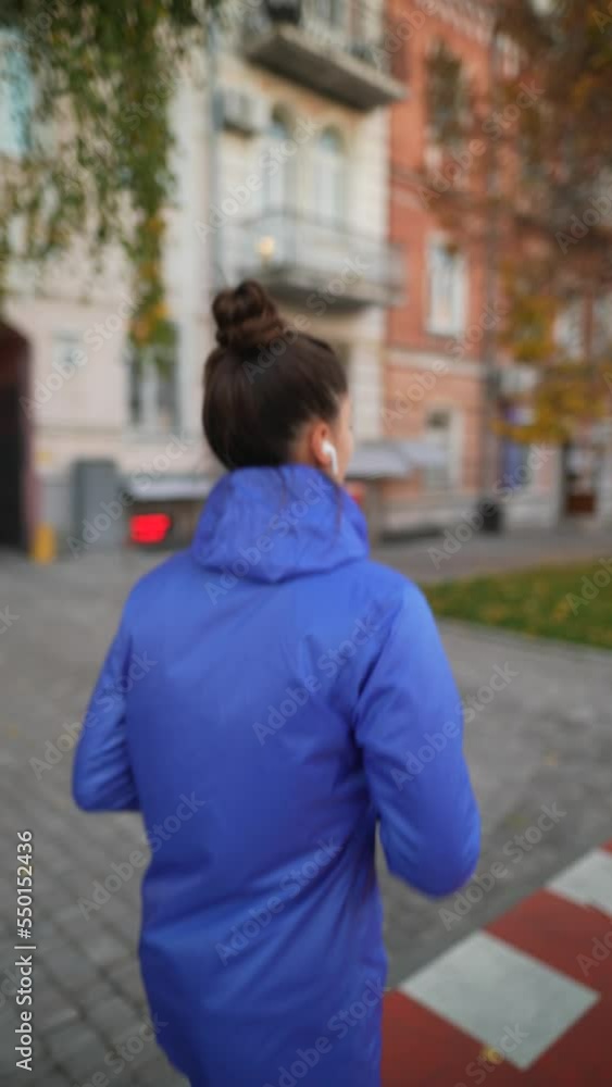 Beautiful adult woman is jogging outdoor on city street autumn day. Beautiful adult woman is jogging outdoor on city street autumn day.