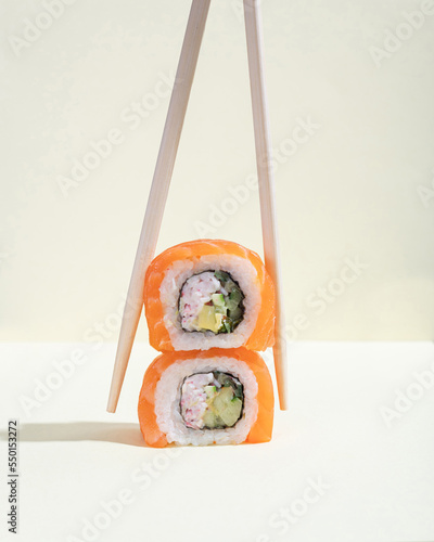 A pair of Japanese salmon sushi, dragon rolls on a bright yellow background. Pop art.