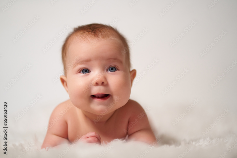 Portrait of an infant on a white background with a cheerful expression of emotion Portrait of an infant on a white background with a cheerful expression of emotion