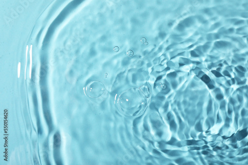 Closeup view of water with rippled surface on light blue background